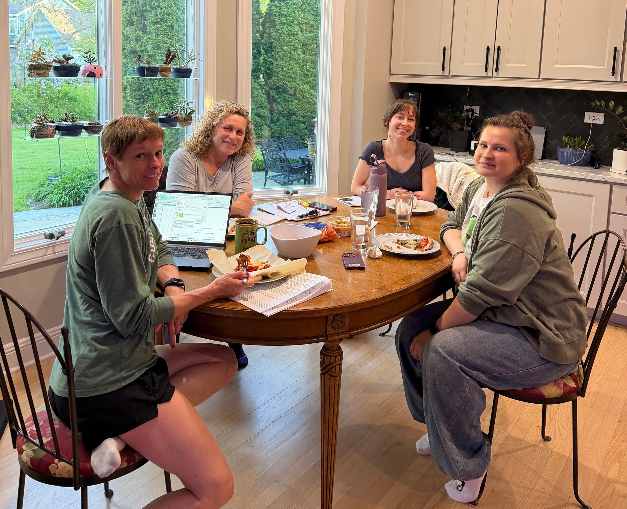 Four vet gathered around a dining table eating Four vet gathered around a dining table eating