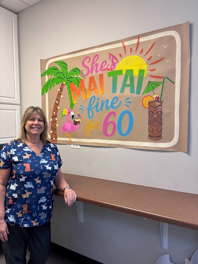 Woman standing next to a colorful birthday sign